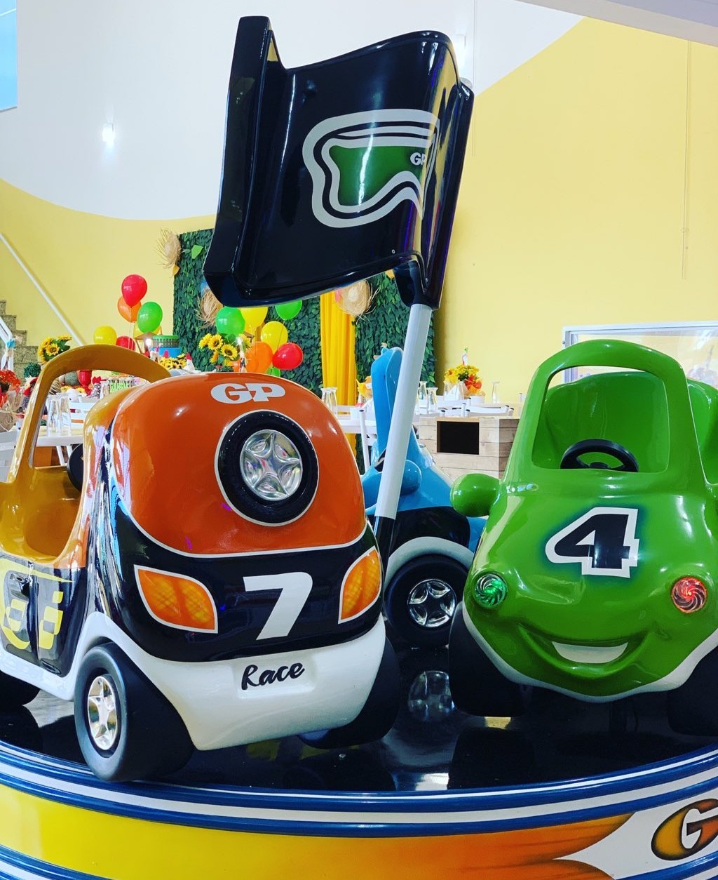 Carrossel de carrinhos coloridos no salão de festas